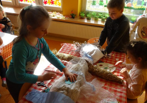 Dzieci dekorują kukłę Marzanny.